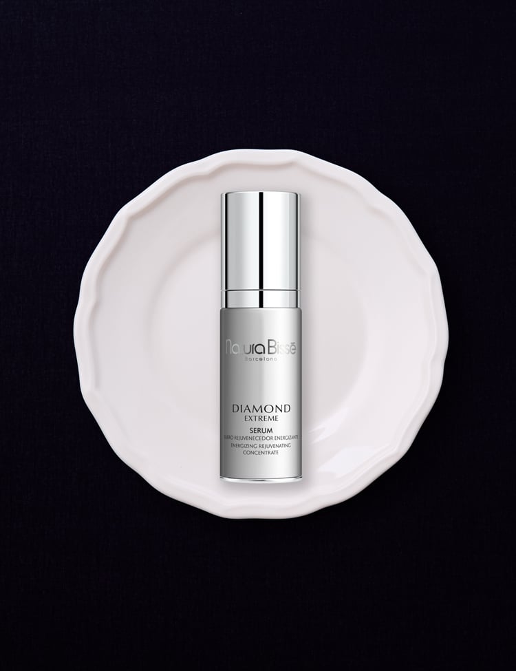 Diamond Extreme Serum ibeing held by a model. She's wearing a gown and looking at the horizon.