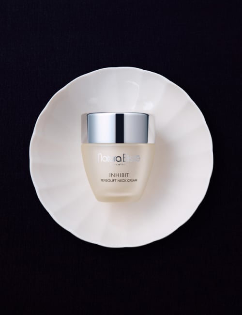 Natura Bissé's Inhibit Tensolift Neck Cream in an elegant packaging placed on top of a glass ball.