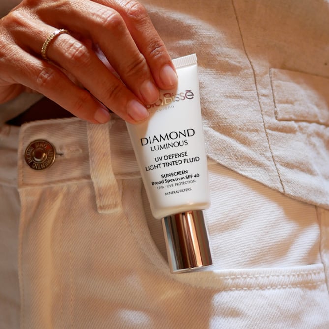 Diamond Luminous SPF on the pocket of a white pair of jeans