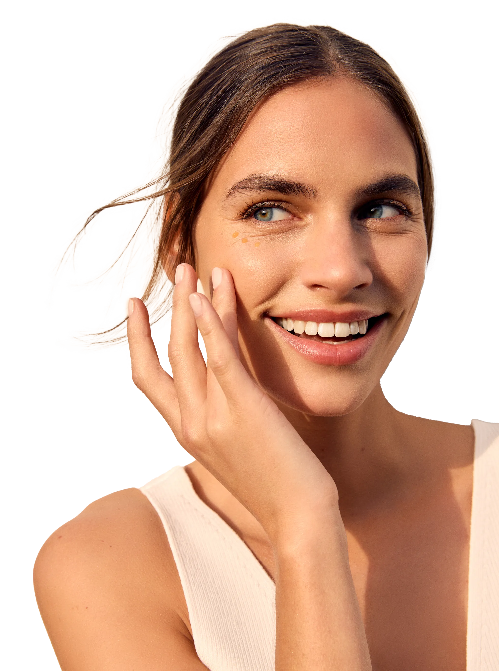 Mujer joven sonriente de pelo castaño aplicándose crema para ojos de Natura Bissé