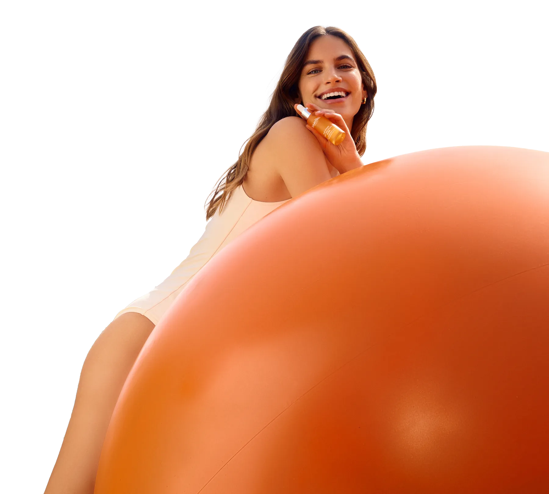Mujer sonriente juega con una pelota naranja de plástico gigante