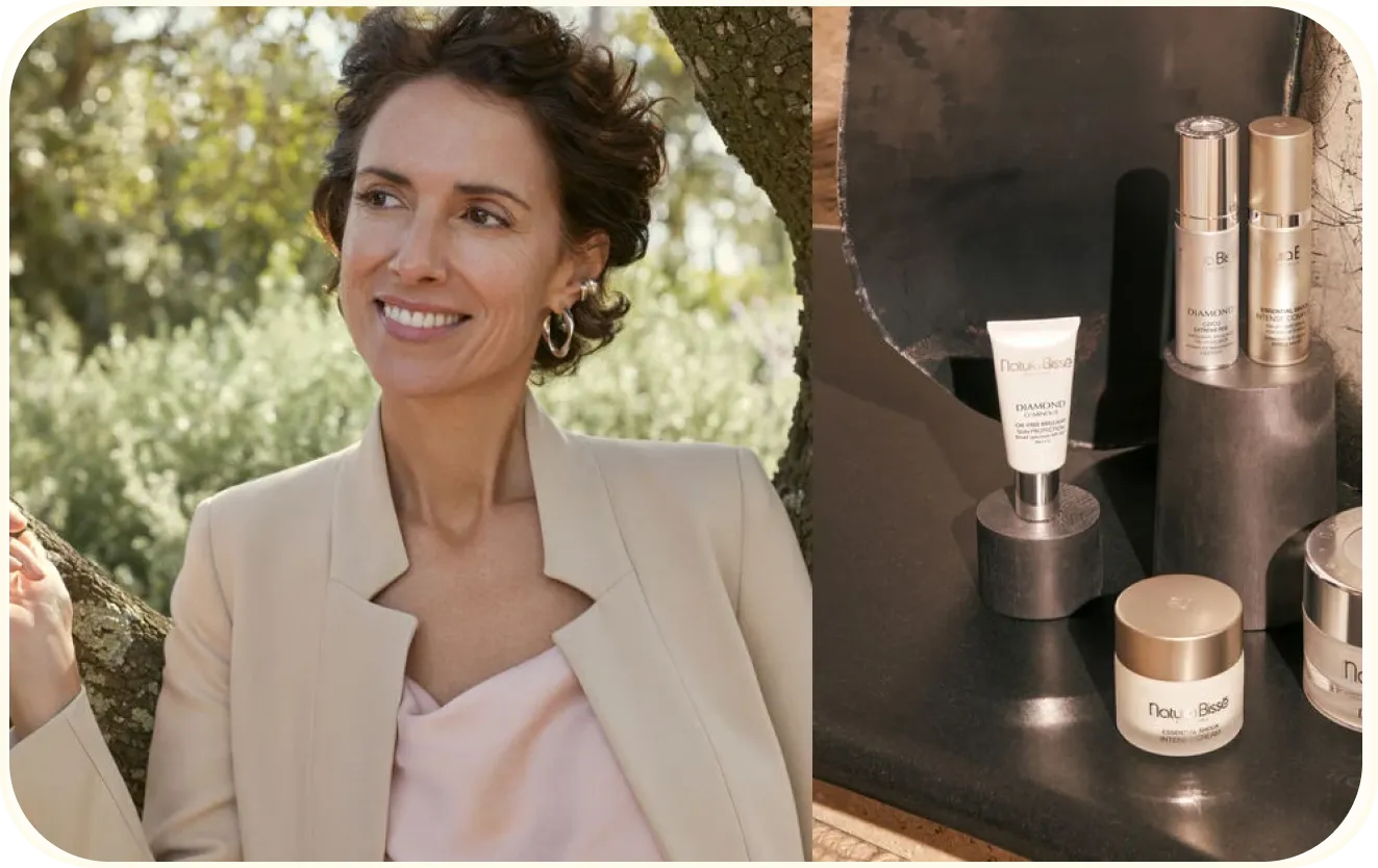 Woman in her fifties smiles. Besides her, a table with Essential Shock products