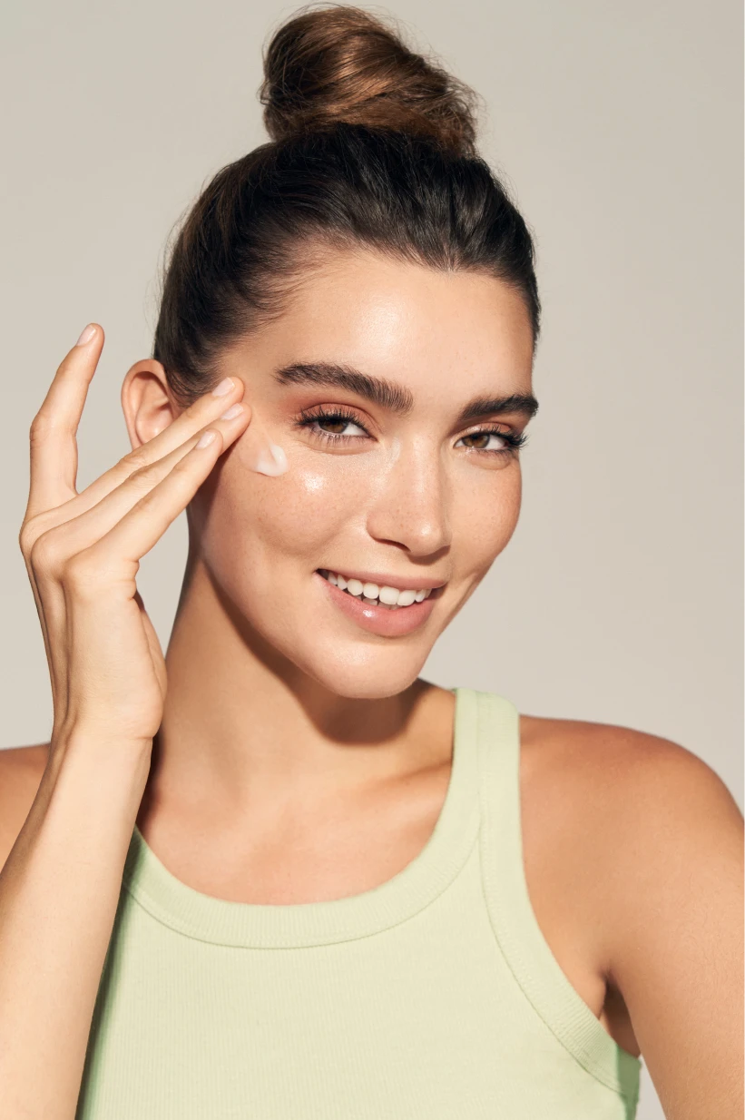 Woman gently touching her cheek during her skincare routine.