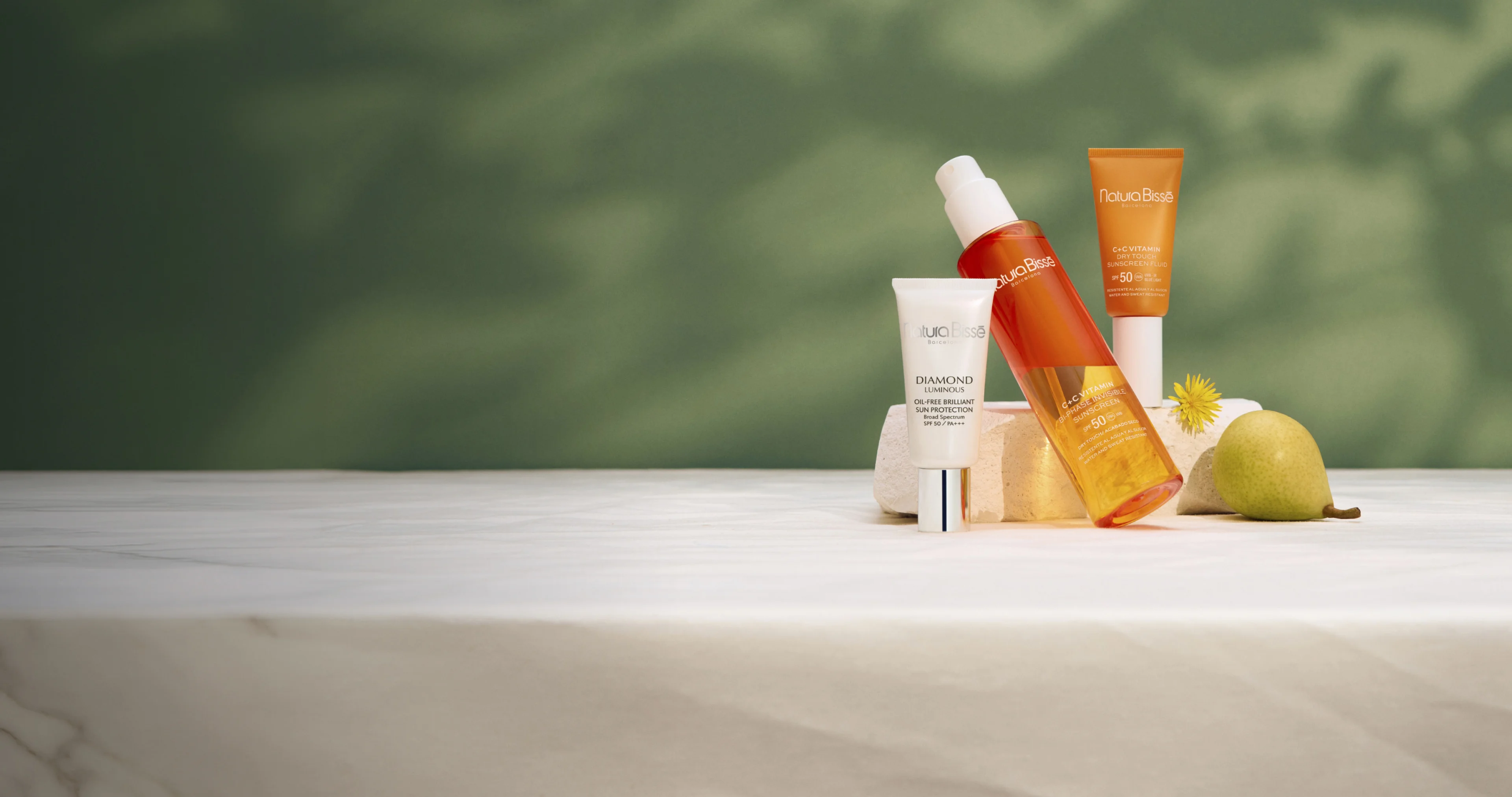 Natura Bisse's different sunscreens over a marble countertop
